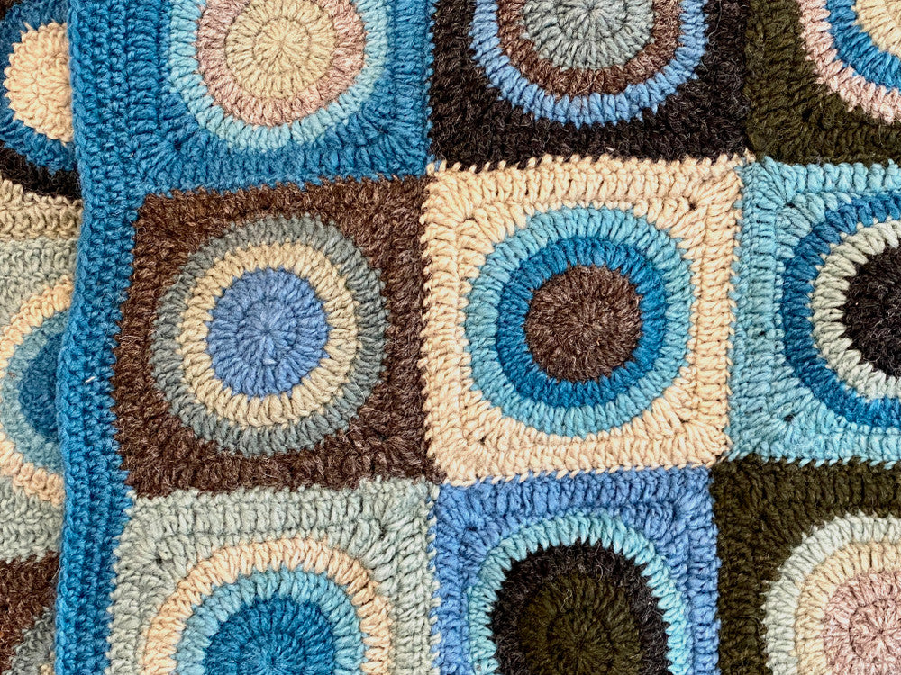 detail Soft wool hand crocheted throw. Purchased from a small group of artisans in Nepal. Colors: a rich medley of teal blue, pale sage, robins egg blue, deep pine, dark charcoal, grey, pale teal and more. 