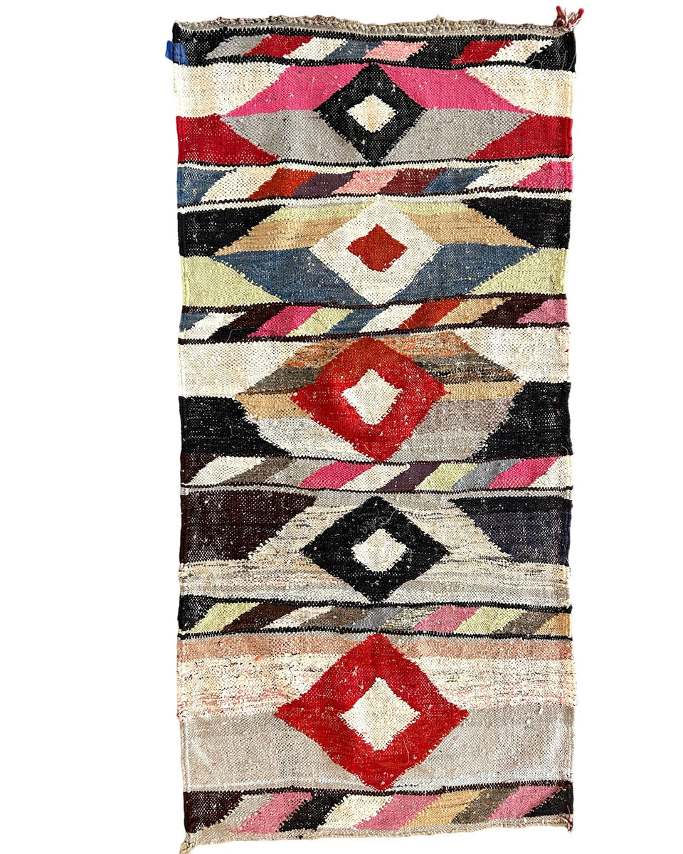 Handwoven rag rug with a dynamic diamond and pattern from weavers in southern Morocco. Beautiful on the floor or on the wall. A medley of colors. Short tied fringe at one end. Size: Approx. 34" x 76"